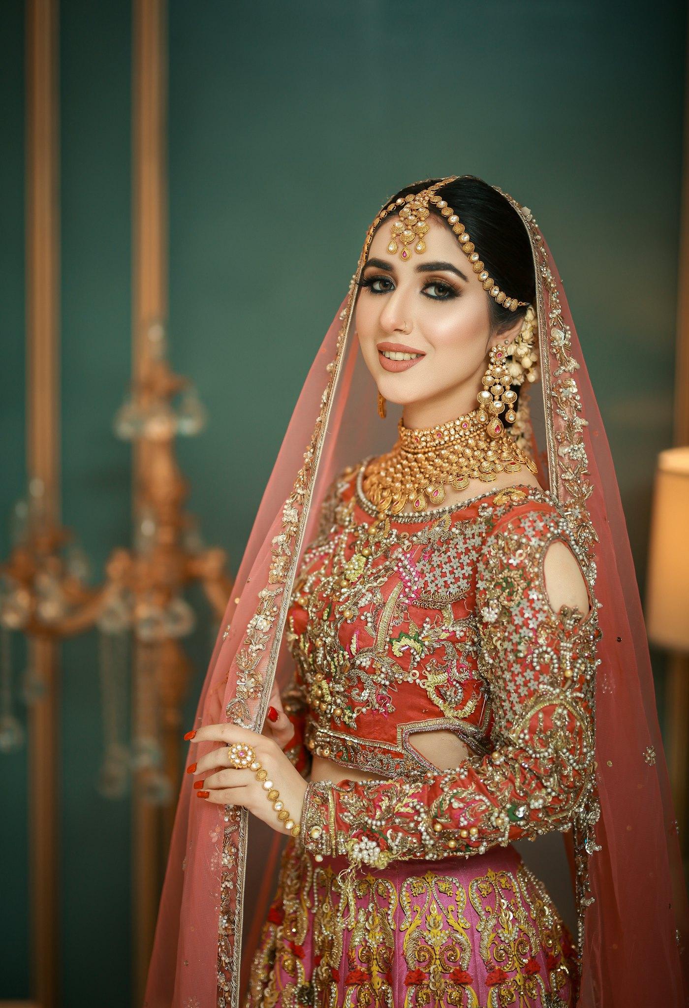 A bride in red and gold with her hair styled for the day